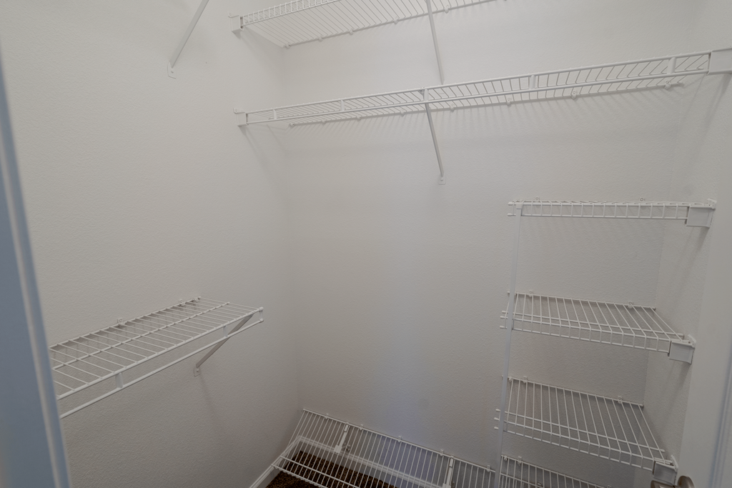 a walk in closet with white walls and shelves at Barton Farms in Greenwood, IN 46143