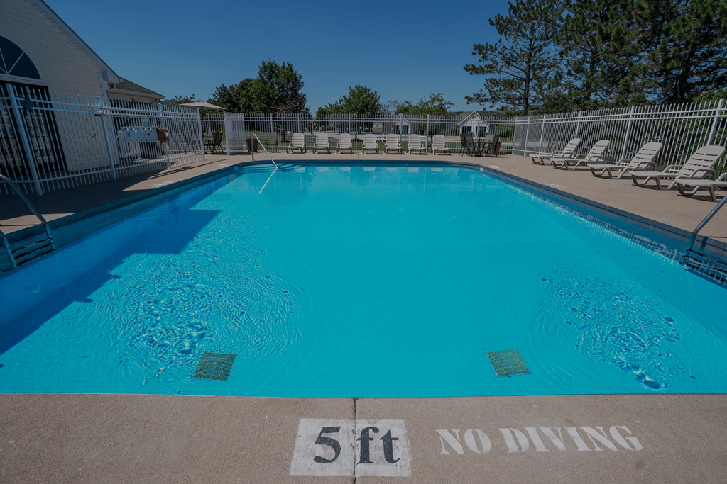 a large pool with chairs and a fence around it at Barton Farms in Greenwood, IN 46143