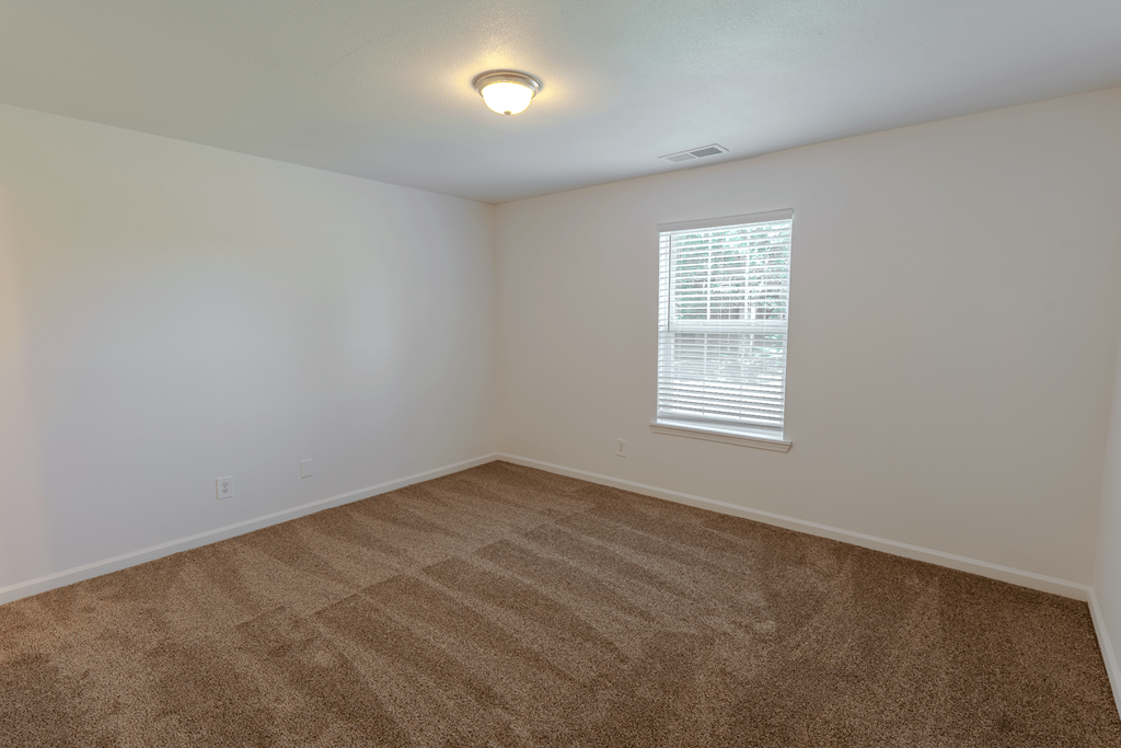 an empty room with carpet and a window at Barton Farms in Greenwood, IN 46143