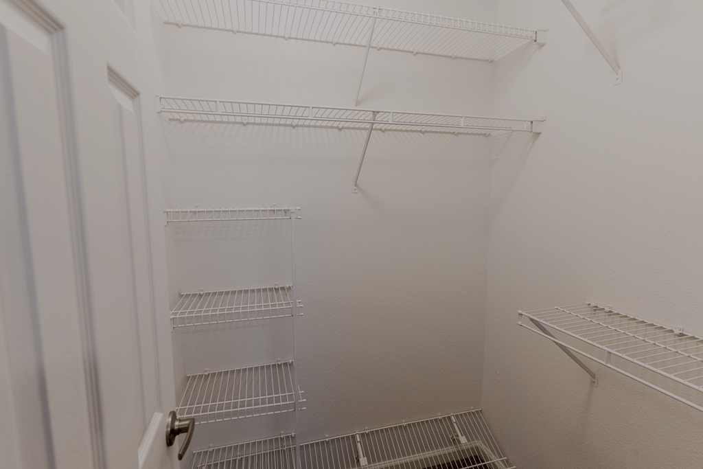 a white walk in closet with white shelves and a white door at Barton Farms in Greenwood, IN 46143