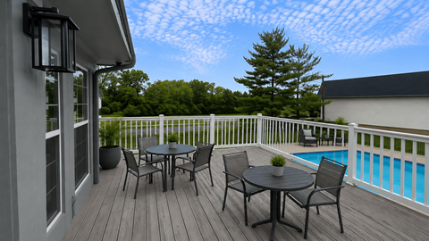 A table and chairs set on a deck overlooking a pool.