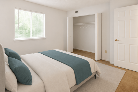 A bedroom with a bed, a window, and a closet.