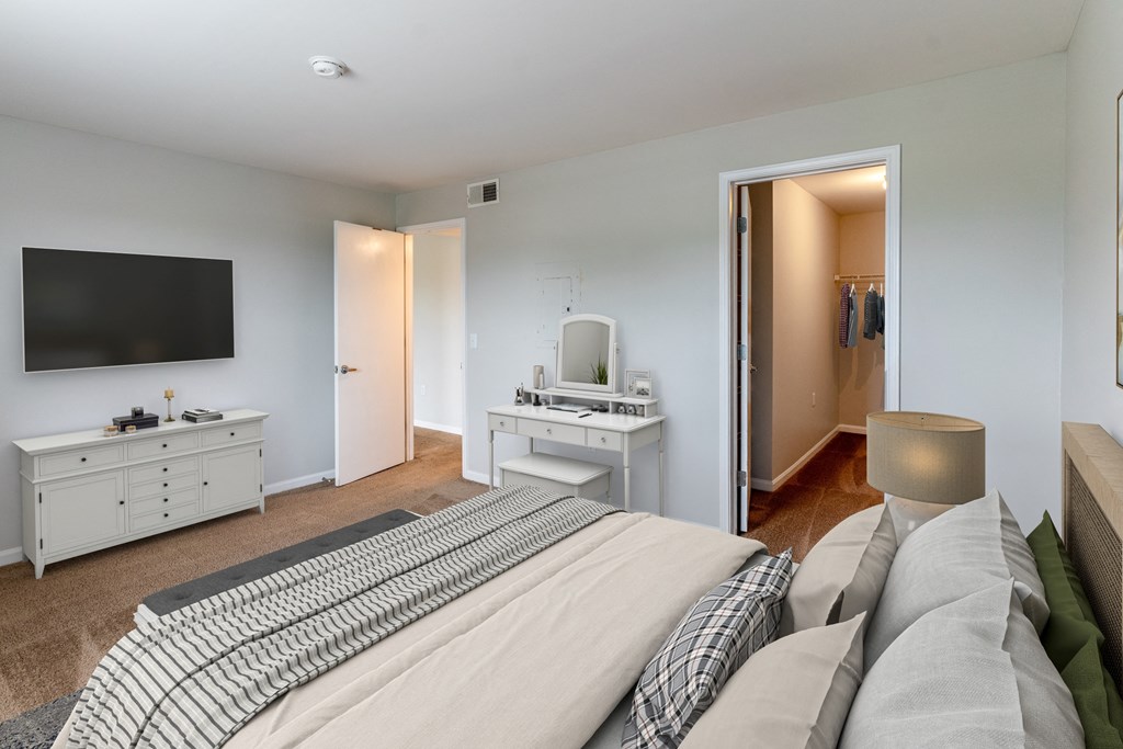 a bedroom with a large bed and a tv on the wall at Walnut Creek Apartments, Kokomo, 46902