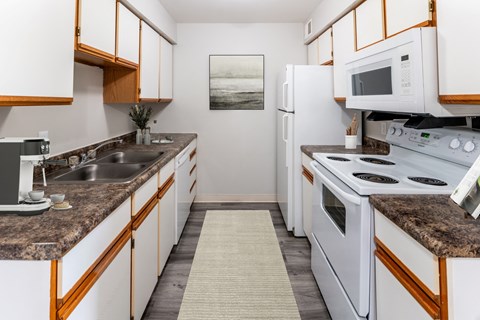 a kitchen with white appliances and granite counter tops