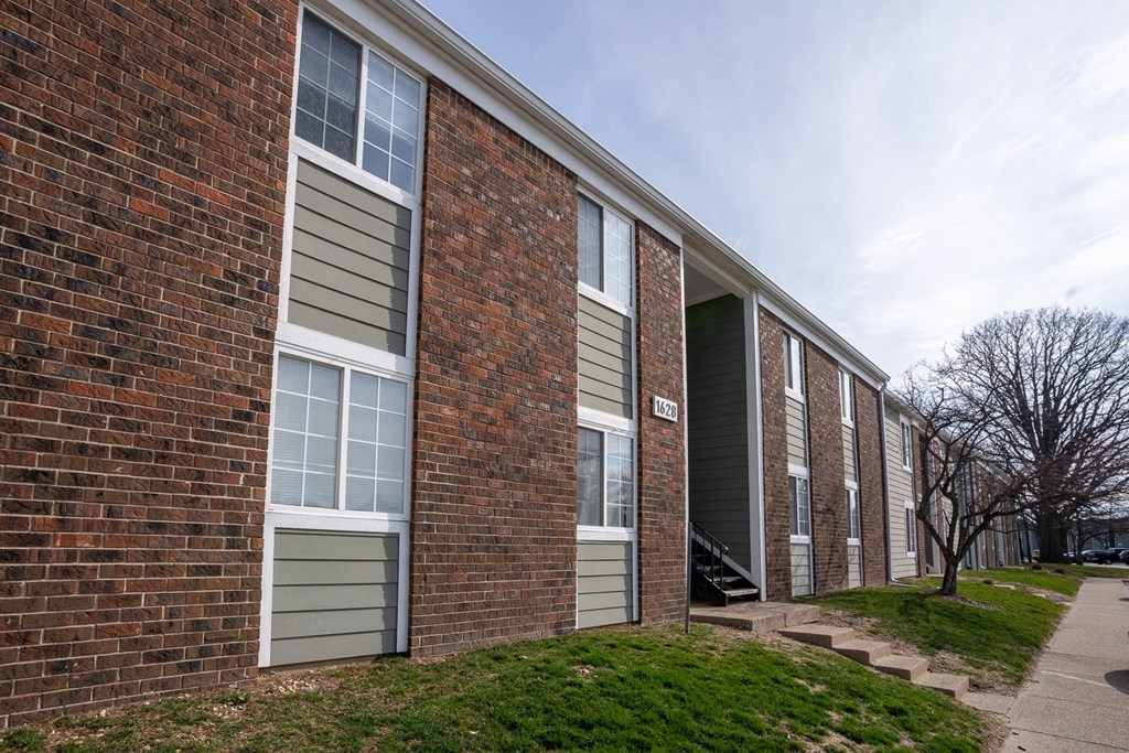a brick building with green siding and a sidewalk  at Pickwick Farms Apartments, Indianapolis, 46260