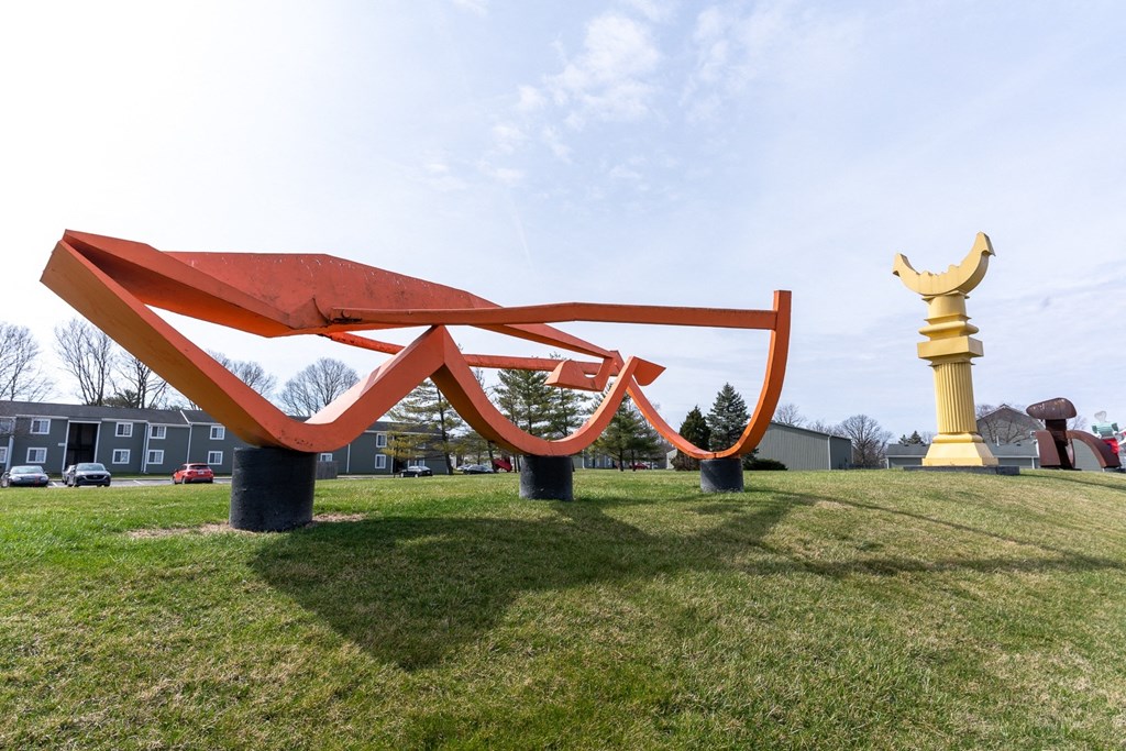 a large red sculpture in the middle of a field  at Pickwick Farms Apartments, Indiana
