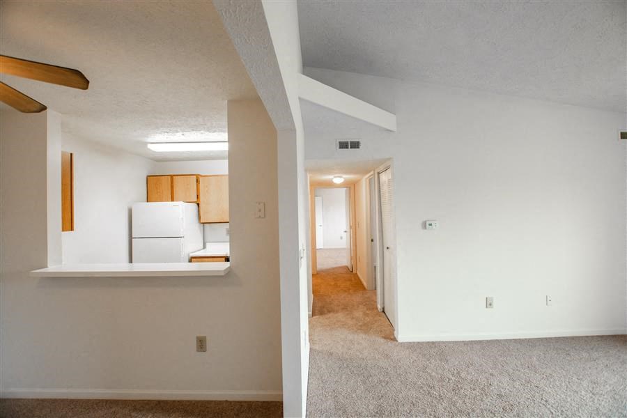 an empty living room and a kitchen in a house at Creekside Square Apartments, Indianapolis