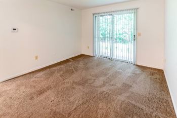 an empty living room with a sliding glass door