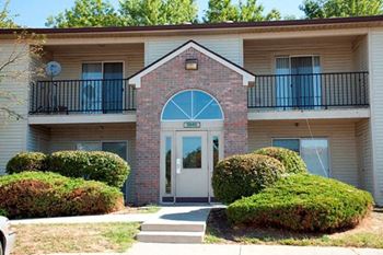 the front entrance of a building with a white door