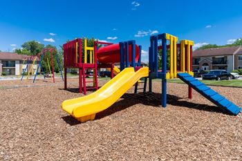 a playground with colorful slides and a picnic table