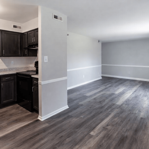 A kitchen with dark wood cabinets and a white wall.