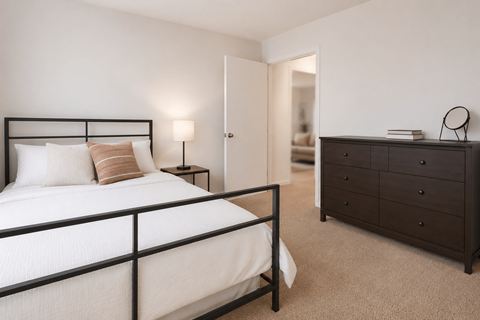 A bedroom with a bed, nightstand, and dresser.