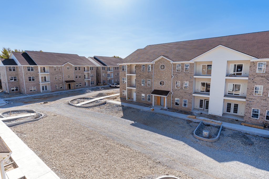 an aerial view of an apartment complex with an empty parking lot