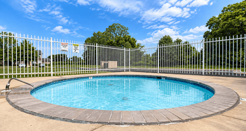 A small round pool surrounded by a fence.