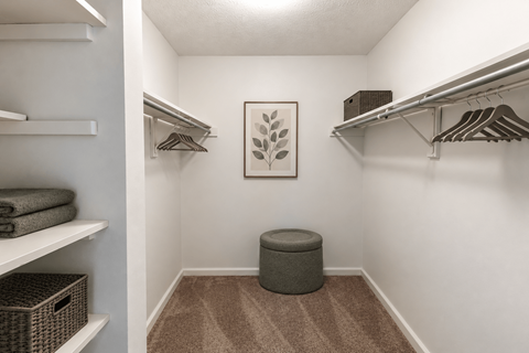 A small closet with a bench in the middle.