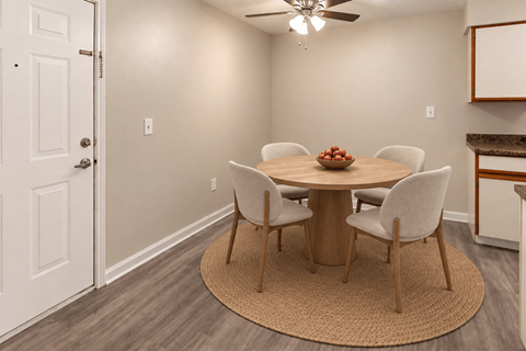 A dining room with a round table and chairs.