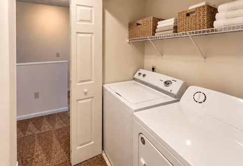 A white washing machine and dryer in a small laundry room.