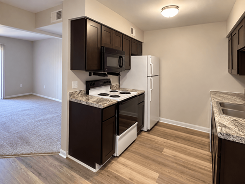 A kitchen with brown cabinets and a white refrigerator.