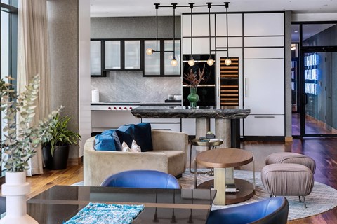 A modern living room with a glass table and blue cushions.