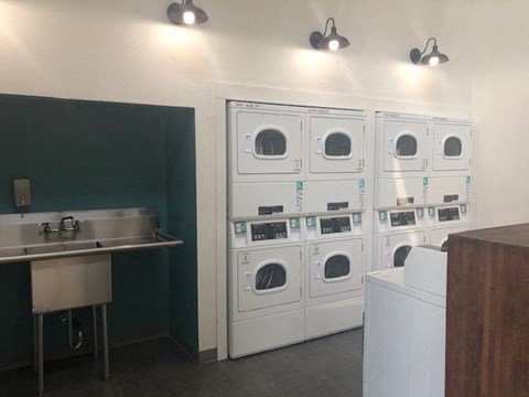 a kitchen with a bunch of washing machines and a sink