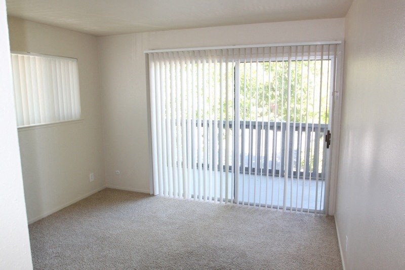 an empty living room with a sliding glass door