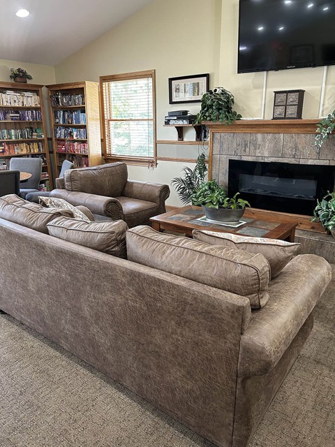 A living room with a large couch and a fireplace.