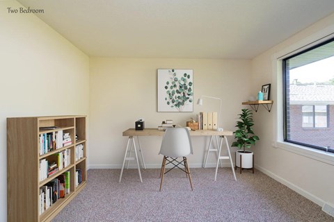 a home office with a desk and a window