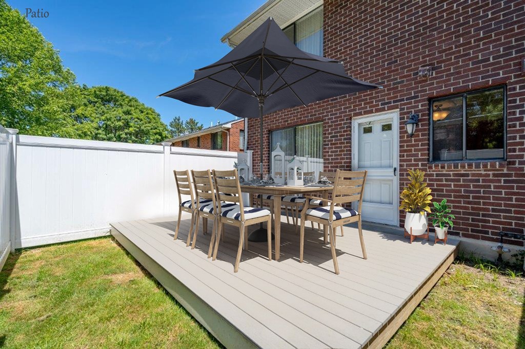 a patio with an umbrella and a table with chairs on it