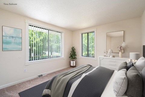 a bedroom with a bed and two windows