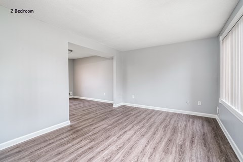 the spacious living room and dining room with wood flooring