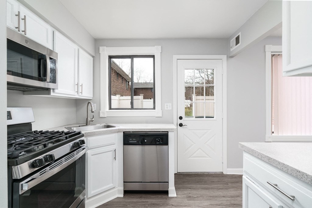 a kitchen with white cabinets and stainless steel appliances