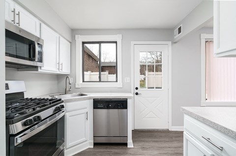 a kitchen with white cabinets and stainless steel appliances