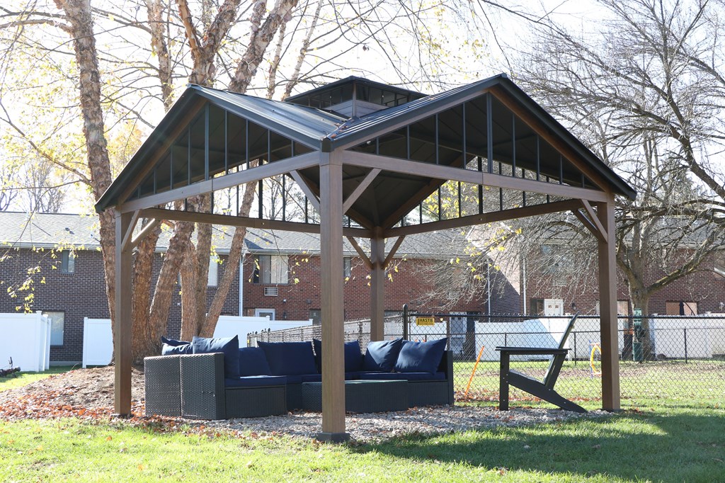 a covered patio with a couch in a backyard