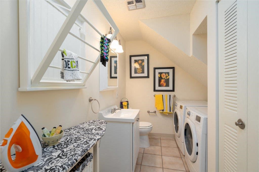 a bathroom with a washing machine and a sink and a toilet