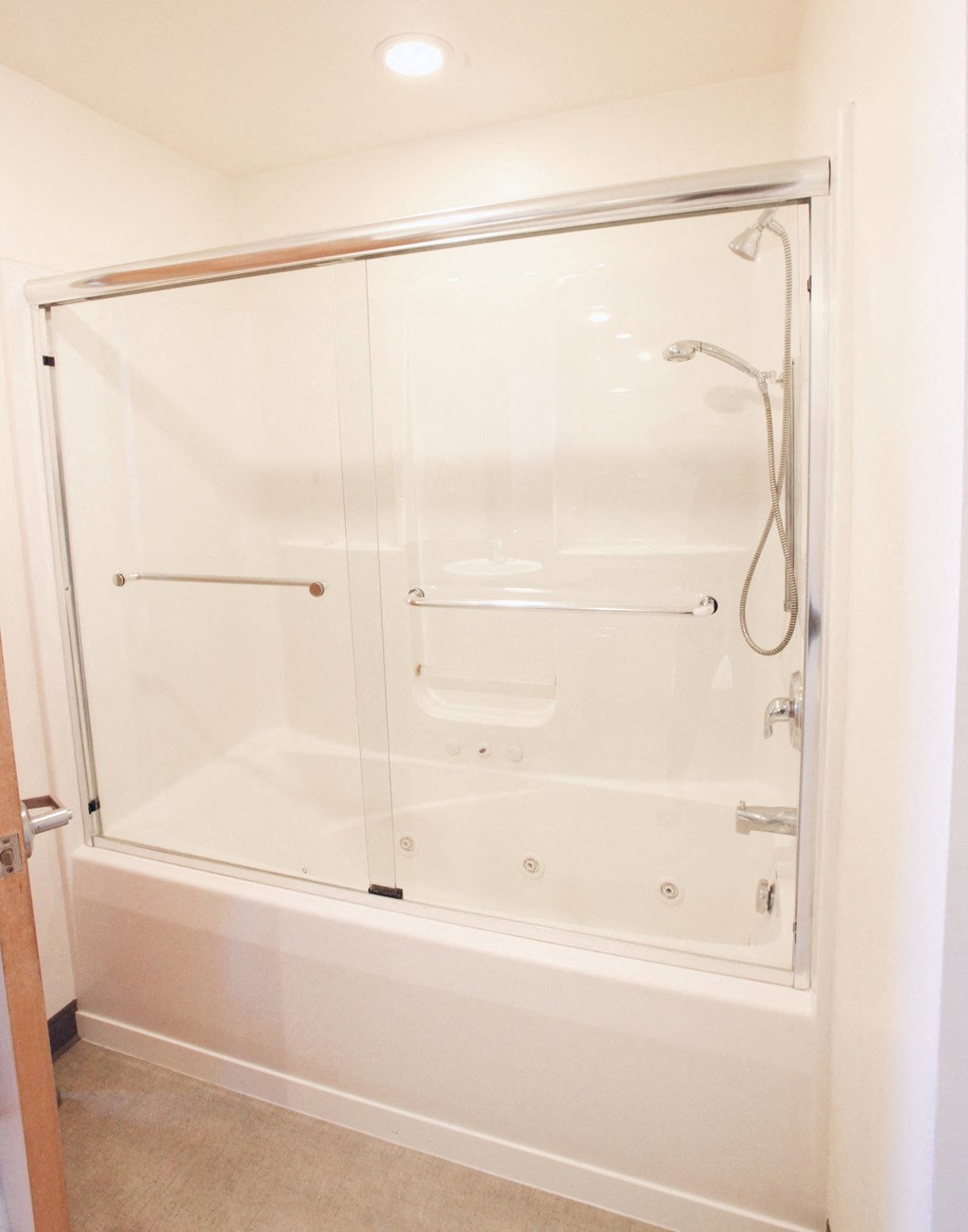 a white shower with a glass door in a bathroom