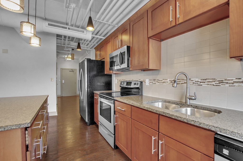 a kitchen with wooden cabinets and a sink and a refrigerator at 100 South Apartments, Buffalo