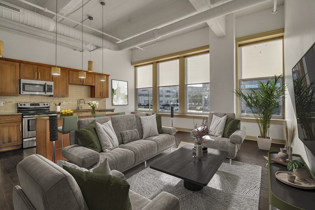 A modern living room with a grey sofa set and a wooden coffee table. at 100 South Apartments, New York, 14202