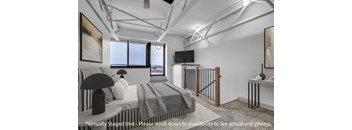 A bedroom with a bed, a television, and a painting on the wall.