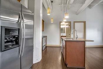 A modern kitchen with a stainless steel refrigerator and wooden cabinets.