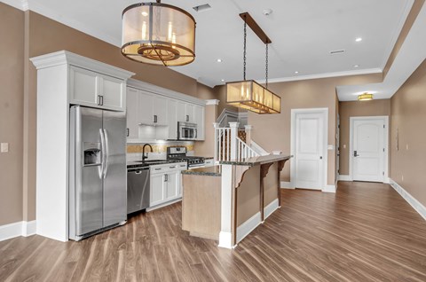 A modern kitchen with wooden floors and stainless steel appliances at The Knights @ 506 Delaware Apartments, Buffalo, NY