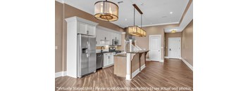 A modern kitchen with wooden floors and stainless steel appliances at The Knights @ 506 Delaware Apartments, Buffalo, NY