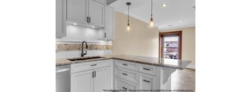A kitchen with a marble countertop and white cabinets at The Knights @ 506 Delaware Apartments, Buffalo