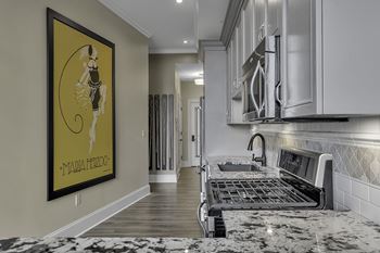 A kitchen with a framed picture of a woman on the wall.