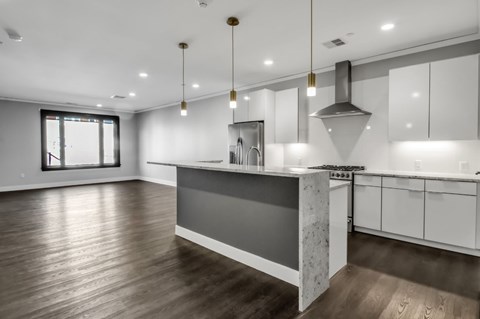 A modern kitchen with a large island and wooden floors.