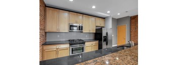 A kitchen with wooden cabinets and a black countertop.