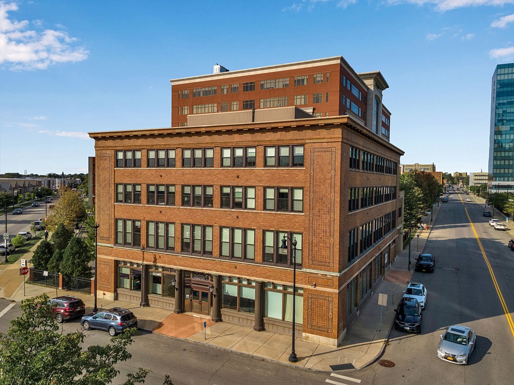 A large red brick building with a parking lot in front.
