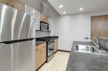 A modern kitchen with a stainless steel refrigerator and a sink.