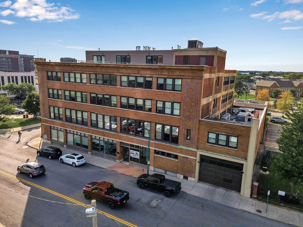 A large red brick building with a parking lot in front.