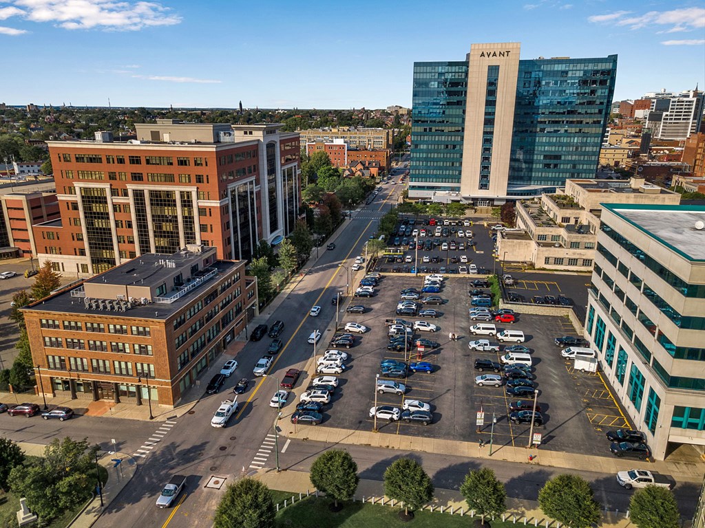 A parking lot with cars and a building with the word AVANT on it.
