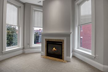 A fireplace in a room with a window on the right.